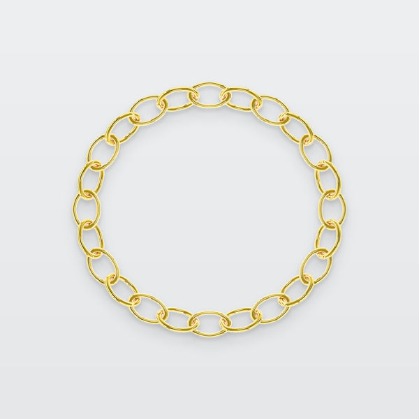 Oval Chain Bracelet in solid gold, photographed flat on a pale grey studio surface